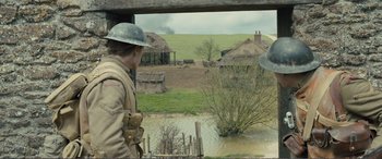 Movie still from “1917” (2019), directed by Sam Mendes – A man wearing a helmet looking out of a window; Wide shot, Over the shoulder angle