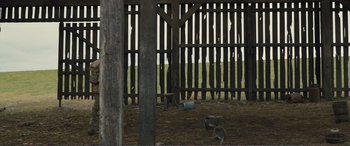 Movie still from “1917” (2019), directed by Sam Mendes – An open area with a wooden fence and a tree in the background; Wide shot, Low angle