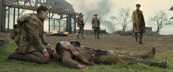 Movie still from “1917” (2019), directed by Sam Mendes – A man laying on the ground in the grass; Wide shot, Over the shoulder angle