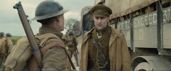 Movie still from “1917” (2019), directed by Sam Mendes – A man in a military uniform talking to another man in an army uniform; Medium shot, Over the shoulder angle