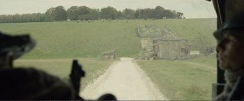 Movie still from “1917” (2019), directed by Sam Mendes – An image of a dirt road in the middle of a green field; Extreme Wide shot, High angle