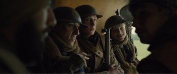 Movie still from “1917” (2019), directed by Sam Mendes – A group of men in uniforms and helmets; Medium shot, Low angle