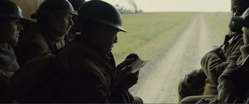 Movie still from “1917” (2019), directed by Sam Mendes – A man wearing a helmet looking at a piece of paper; Medium shot, Over the shoulder angle