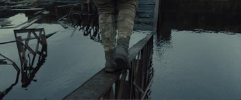 Movie still from “1917” (2019), directed by Sam Mendes – A man walking across a bridge over a river; Wide shot, Low angle
