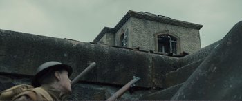 Movie still from “1917” (2019), directed by Sam Mendes – A building that has been built on the side of a wall; Medium shot, Low angle