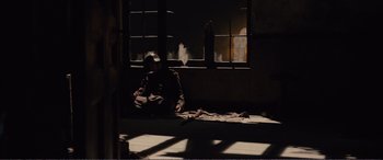 Movie still from “1917” (2019), directed by Sam Mendes – A man sitting on the floor in front of a window; Wide shot, High angle