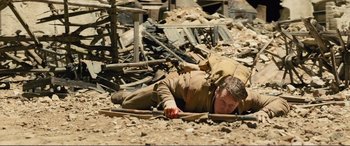 Movie still from “1917” (2019), directed by Sam Mendes – A man laying on the ground in the rubble; Wide shot, High angle