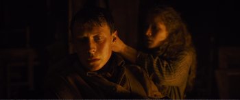 Movie still from “1917” (2019), directed by Sam Mendes – A man and a woman in a dimly - lit room; Close Up shot, Over the shoulder angle
