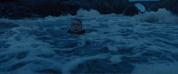 Movie still from “1917” (2019), directed by Sam Mendes – A man in the water in front of some rocks; Wide shot, High angle
