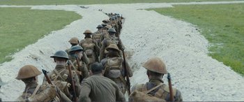 Movie still from “1917” (2019), directed by Sam Mendes – A group of men are walking down a dirt path; Wide shot, High angle