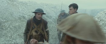 Movie still from “1917” (2019), directed by Sam Mendes – A group of men standing next to each other on top of a hill; Medium shot, Over the shoulder angle
