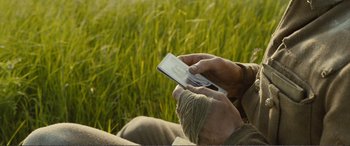 Movie still from “1917” (2019), directed by Sam Mendes – A person holding a cell phone in their hands; Extreme Close Up shot, High angle