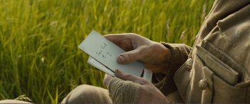 Movie still from “1917” (2019), directed by Sam Mendes – A person holding a piece of paper in their hands; Close Up shot, Over the shoulder angle