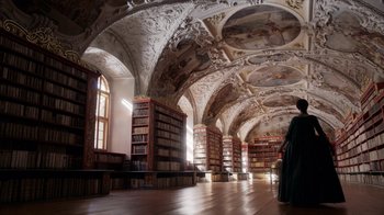 Movie still from “Outlander” (2014), created by Ronald D. Moore – A person standing in front of a large library filled with lots of books; Extreme Wide shot, Low angle