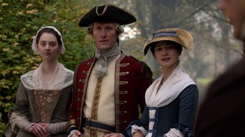 Movie still from “Outlander” (2014), created by Ronald D. Moore – A man and two women dressed in period costumes; Medium shot, High angle