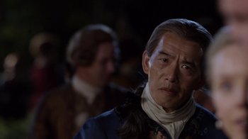 Movie still from “Outlander” (2014), created by Ronald D. Moore – A person wearing a suit and tie; Close Up shot, Over the shoulder angle