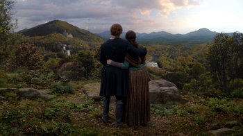 Movie still from “Outlander” (2014), created by Ronald D. Moore – A man and a woman standing on top of a hill; Extreme Wide shot, High angle