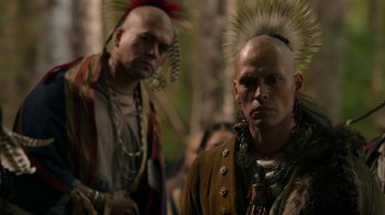 Movie still from “Outlander” (2014), created by Ronald D. Moore – Two native american men standing next to each other; Close Up shot, Over the shoulder angle