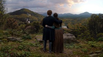 Movie still from “Outlander” (2014), created by Ronald D. Moore – A man and a woman standing on top of a hill; Extreme Wide shot, High angle
