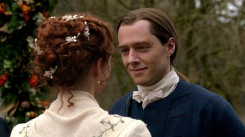 Movie still from “Outlander” (2014), created by Ronald D. Moore – A man and a woman standing next to each other in front of trees; Close Up shot, Over the shoulder angle