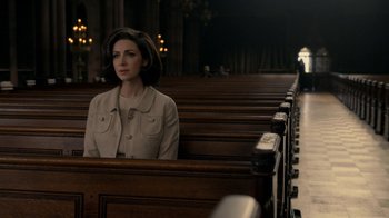 Movie still from “Outlander” (2014), created by Ronald D. Moore – A woman sitting alone in a church pews; Medium shot, High angle
