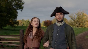 Movie still from “Outlander” (2014), created by Ronald D. Moore – A man and a woman standing next to each other; Medium shot, Low angle