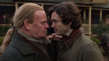 Movie still from “Outlander” (2014), created by Ronald D. Moore – Two men are looking at one another in the street; Close Up shot, Over the shoulder angle