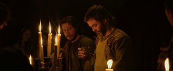 Movie still from “Outlaw King” (2018), directed by David Mackenzie – A couple of men standing in front of some candles; Medium shot, Low angle