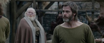 Movie still from “Outlaw King” (2018), directed by David Mackenzie – A man with long hair and a beard standing next to another man with long hair and a beard; Medium shot, Over the shoulder angle
