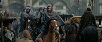 Movie still from “Outlaw King” (2018), directed by David Mackenzie – A group of men riding on the backs of horses; Wide shot, Over the shoulder angle