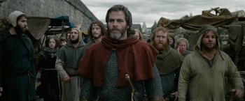 Movie still from “Outlaw King” (2018), directed by David Mackenzie – A group of men standing next to each other in a row; Medium shot, Over the shoulder angle