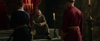 Movie still from “Outlaw King” (2018), directed by David Mackenzie – A man sitting in front of a lit candle; Wide shot, Over the shoulder angle