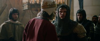 Movie still from “Outlaw King” (2018), directed by David Mackenzie – A man in a chain mail hood and a man in a red robe; Close Up shot, Over the shoulder angle
