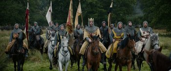 Movie still from “Outlaw King” (2018), directed by David Mackenzie – A group of men riding on the backs of horses; Wide shot, Low angle