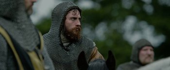 Movie still from “Outlaw King” (2018), directed by David Mackenzie – A bearded man in a chain mail outfit on a horse; Close Up shot, Low angle