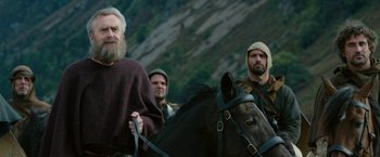 Movie still from “Outlaw King” (2018), directed by David Mackenzie – A group of men on horses in a field; Medium shot, Low angle