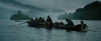 Movie still from “Outlaw King” (2018), directed by David Mackenzie – A group of people in a boat on a body of water; Wide shot, High angle