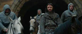 Movie still from “Outlaw King” (2018), directed by David Mackenzie – Two men are dressed in medieval clothing while riding horses; Medium shot, Low angle