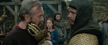 Movie still from “Outlaw King” (2018), directed by David Mackenzie – Two men and two women in medieval garb talking to each other; Close Up shot, Over the shoulder angle
