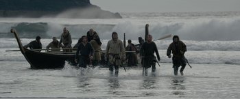 Movie still from “Outlaw King” (2018), directed by David Mackenzie – A group of people walking out of the ocean; Wide shot, High angle