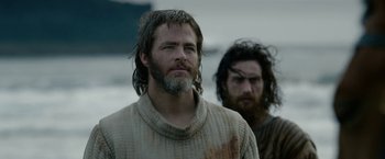 Movie still from “Outlaw King” (2018), directed by David Mackenzie – Two men standing next to each other on a beach; Medium shot, Low angle