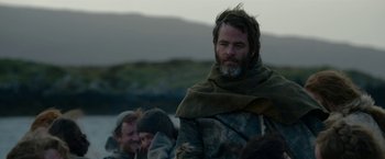 Movie still from “Outlaw King” (2018), directed by David Mackenzie – A man with a beard and a long scarf around his neck; Medium shot, Over the shoulder angle