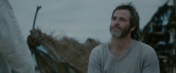 Movie still from “Outlaw King” (2018), directed by David Mackenzie – A man with a beard is standing in a field; Close Up shot, Low angle