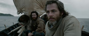 Movie still from “Outlaw King” (2018), directed by David Mackenzie – A man with long hair and a beard sitting next to another man with long hair; Medium shot, Low angle