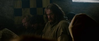 Movie still from “Outlaw King” (2018), directed by David Mackenzie – A man with long hair sitting in front of another man; Medium shot, Over the shoulder angle