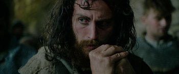 Movie still from “Outlaw King” (2018), directed by David Mackenzie – A person with long hair and a beard; Close Up shot, Low angle