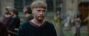Movie still from “Outlaw King” (2018), directed by David Mackenzie – A man with a beard is holding a sword; Close Up shot, Over the shoulder angle