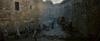 Movie still from “Outlaw King” (2018), directed by David Mackenzie – A group of people standing next to each other on a street; Extreme Wide shot, High angle