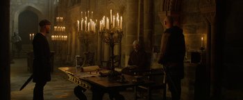 Movie still from “Outlaw King” (2018), directed by David Mackenzie – Two men sitting in front of a table with candles on top of it; Wide shot, High angle