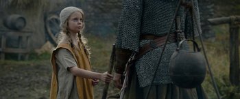 Movie still from “Outlaw King” (2018), directed by David Mackenzie – A young girl holding a stick near an older man; Medium shot, Over the shoulder angle